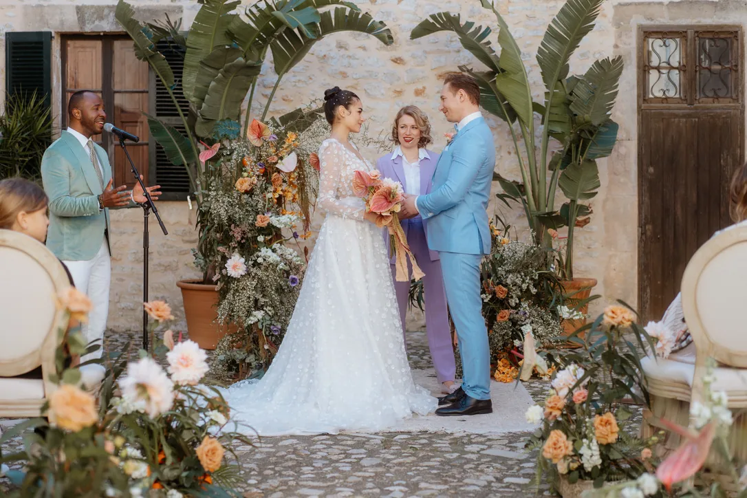 Freie Trauung mit Live-Gesang auf Mallorca – Hochzeitsband Mallorca mit Inan Lima Live-Gesang bei der freien Trauung auf einer Finca auf Mallorca: Sänger am Mikrofon, Brautpaar vor Blumenbogen